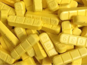 Yellow Xanax Bars (alprazolam) stacked, highlighting their rectangular shape and distinct yellow color, ideal for anxiety treatment.